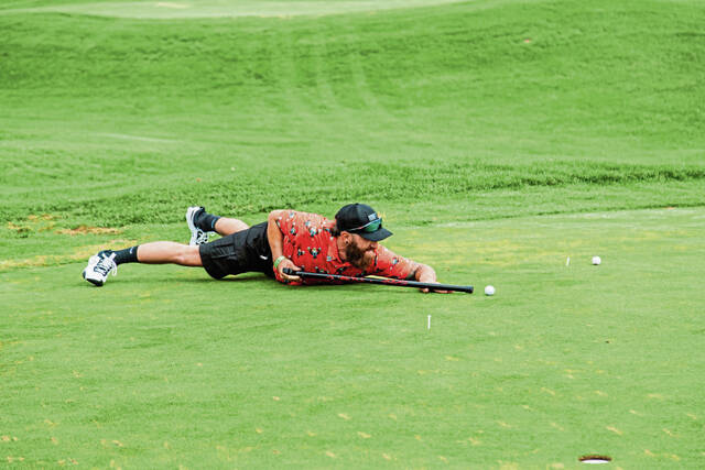 Derrick Komarinski takes part in a putting game during the second annual Rhodes Cancer Foundation golf outing on July 19 at Glengarry Golf Links in Unity.